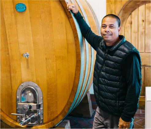 Winemaker Leo Gabica standing beside a large oak cask in the Sweet Cheeks cellar